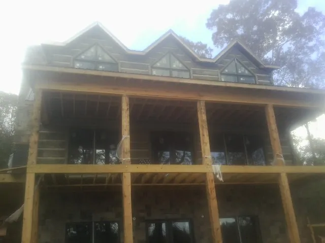 Dormers and porch framing on a large log home under construction — Roof Coating work by our crew in Welches