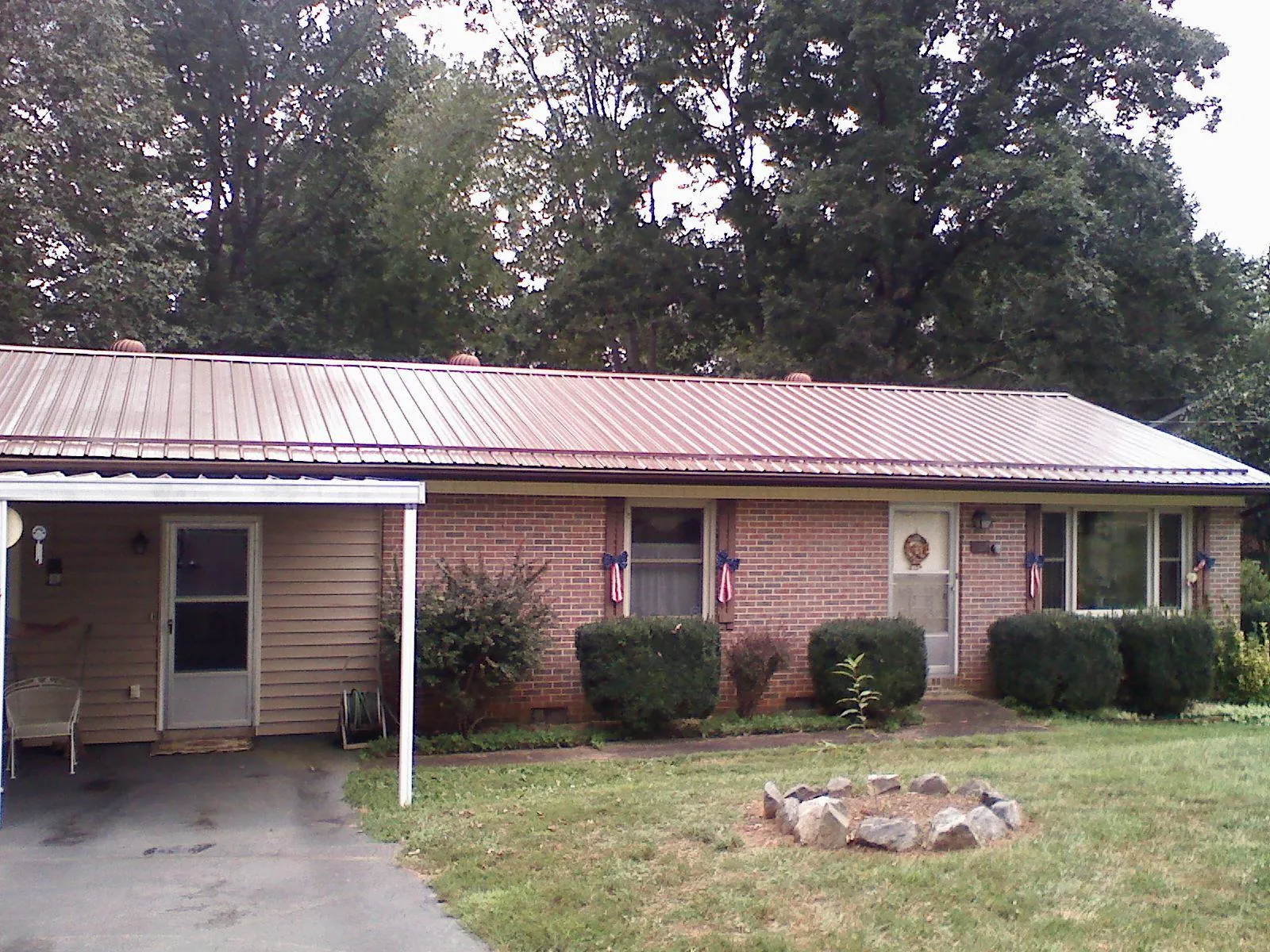 Bronze metal roof and carport on a brick ranch home — Roof Repair work by our crew in Welches
